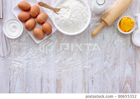 Homemade dough recipe (eggs, flour, milk, sugar) on a wooden table top view. 80655352