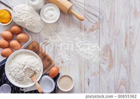 Homemade dough recipe (eggs, flour, milk, sugar) on a wooden table top view. Homemade dough recipe (eggs, flour, milk, sugar) on a wooden table top view. 80655362