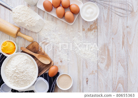 Homemade dough recipe (eggs, flour, milk, sugar) on a wooden table top view. Homemade dough recipe (eggs, flour, milk, sugar) on a wooden table top view. 80655363