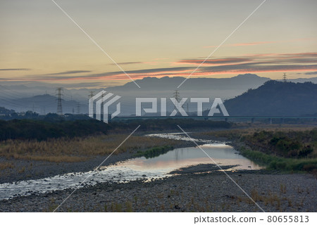 建在勘廣河床上的一座橋；一座電力塔，一片霞光燦爛的天空，一座雲霧書寫的電力塔，也倒映在水面上。 80655813