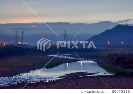 建在勘廣河床上的一座橋；一座電力塔，一片霞光燦爛的天空，一座雲霧書寫的電力塔，也倒映在水面上。 80655816