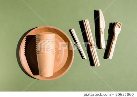 Set of Eco friendly tableware for home and picnic on green background. Plastic free. Zero waste concept. Disposable paper tableware, cups, plates, wooden forks, knives, spoons and bamboo straws Set of Eco friendly tableware for home and picnic on green background. Plastic free. Zero waste concept. Disposable paper tableware, cups, plates, wooden forks, knives, spoons and bamboo straws 80655860