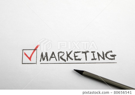 Checkmark at the word marketing. Pencil on a white sheet Checkmark at the word marketing. Pencil on a white sheet 80656541