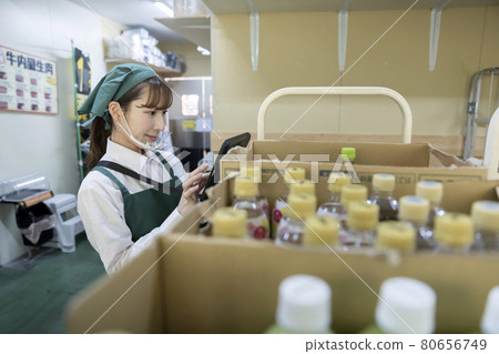 一名女僱員，在一家超市的後院裡用口罩工作 80656749