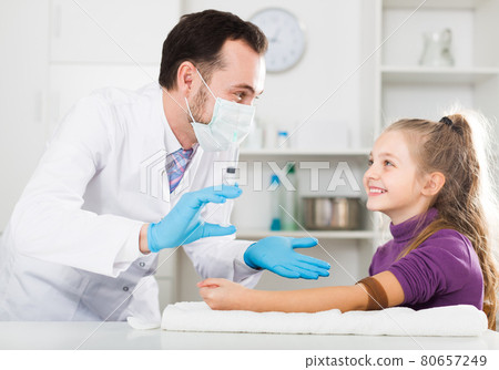 Adult doctor ready to make injection to visitor 80657249