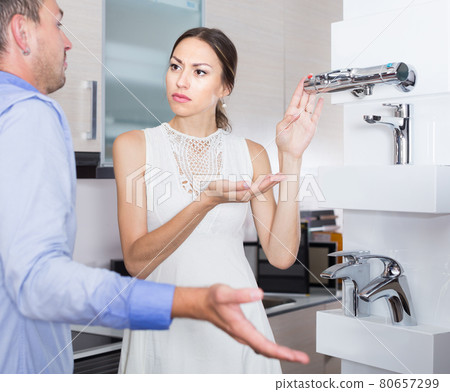 Unhappy girl communicating with seller of kitchen accessories Unhappy girl communicating with seller of kitchen accessories 80657299