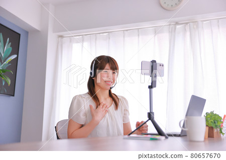Online meeting on smartphone _ A woman who smiles and talks about her thoughts 80657670