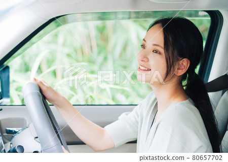 A woman driving a car 80657702