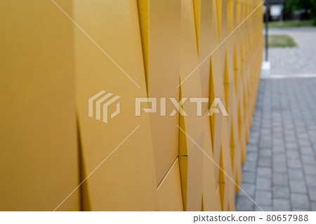 Yellow metallic facade of the building. Paved sidewalk. Abstract texture background Yellow metallic facade of the building. Paved sidewalk. Abstract texture background 80657988