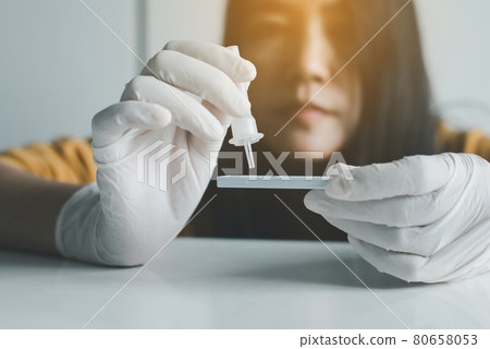 Asian patient woman using a covid-19 self test rapid antigen testing kit at home Asian patient woman using a covid-19 self test rapid antigen testing kit at home 80658053