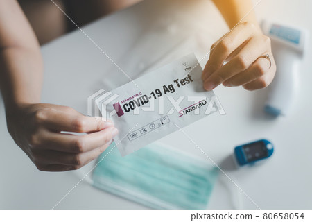 Woman using a covid-19 self test rapid antigen testing kit at home Woman using a covid-19 self test rapid antigen testing kit at home 80658054