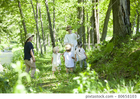 Nursery teachers and children playing in the forest 80658103