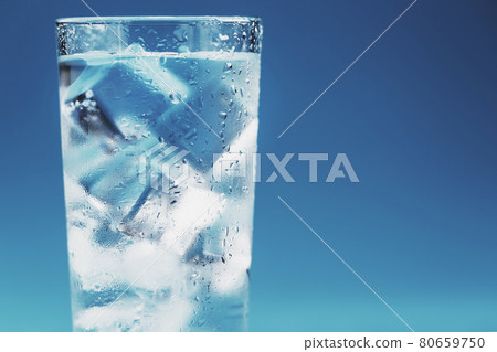 Glass with water and ice cubes on a blue background 80659750