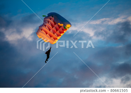 Skydiver On Colorful Parachute In Sky Skydiver On Colorful Parachute In Sky 80661505