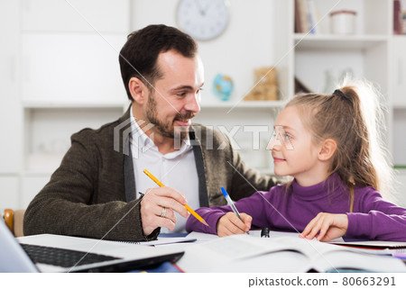 Father helping daughter with homework 80663291