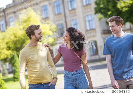Three friends spending time together and smiling nicely Three friends spending time together and smiling nicely 80664583