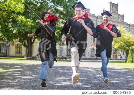 Three graduates running in the park and having fun Three graduates running in the park and having fun 80664586