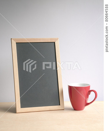 Blank blackboard with red coffee cup on wood table. Blank blackboard with red coffee cup on wood table. 80664588