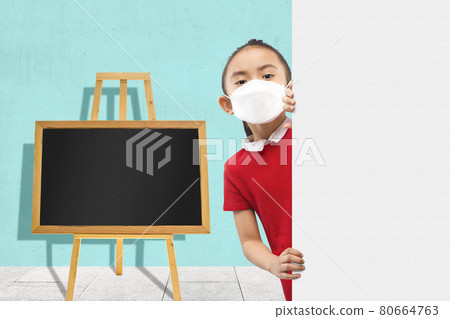 Asian little girl wearing the mask standing beside the wall Asian little girl wearing the mask standing beside the wall 80664763