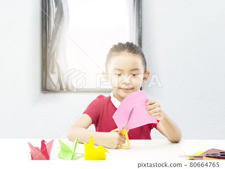 Asian little girl cutting a paper Asian little girl cutting a paper 80664765