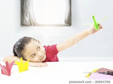 Asian little girl playing with goose paper Asian little girl playing with goose paper 80664766