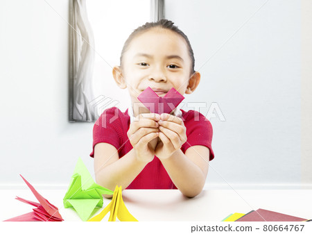 Asian little girl showing her papercraft Asian little girl showing her papercraft 80664767