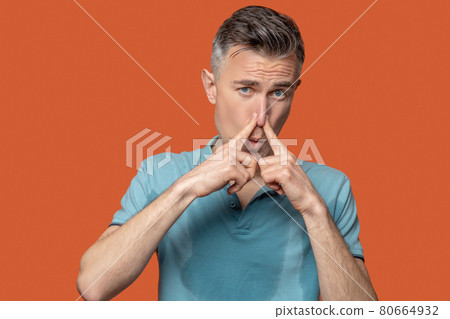 Unhappy man covering nose with fingers Unhappy man covering nose with fingers 80664932