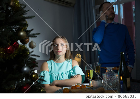 Offended woman and man with phone at Christmas night Offended woman and man with phone at Christmas night 80665033