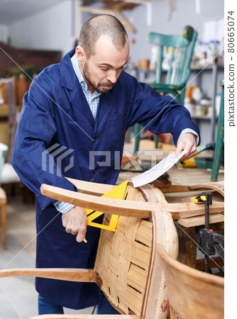 Craftsman making drawing of vintage chair 80665074