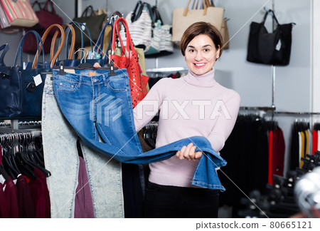 Young girl deciding on new jeans 80665121