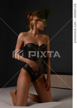 portrait of beautiful woman in black leather corset and venetian mask 80666126