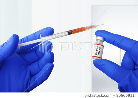 Health worker hand with gloves holding syringe and covid 19 vaccines 80666931