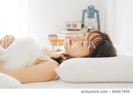 A woman sleeping in bed A woman sleeping in bed 80667906