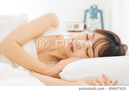 A woman sleeping in bed 80667920