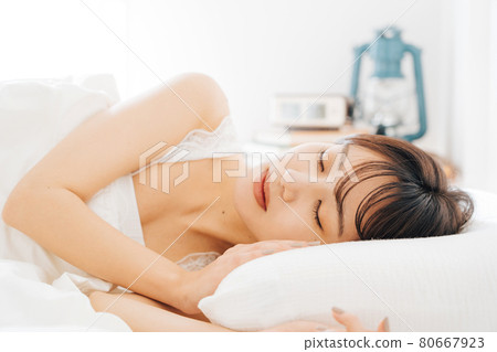 A woman sleeping in bed 80667923