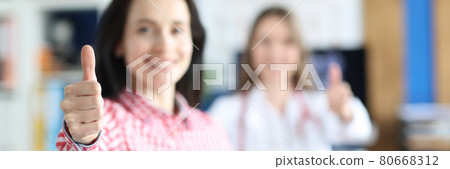 Doctor and woman patient show thumbs up gesture 80668312