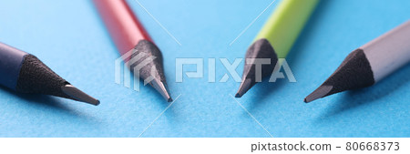 Four multi-colored wooden pencils lie on blue background 80668373