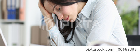 Tired exhausted young woman sits at laptop in office 80668395