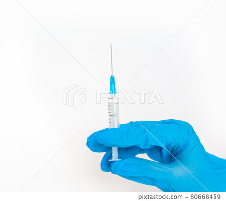 The doctor holds a vaccination syringe on a white background.  80668459