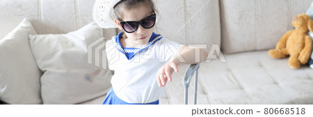 Little girl in hat and sunglasses with yellow suitcase Little girl in hat and sunglasses with yellow suitcase 80668518