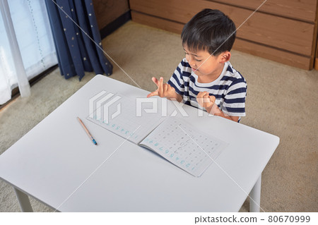 Elementary school boy counting with fingers in math calculations Elementary school boy counting with fingers in math calculations 80670999