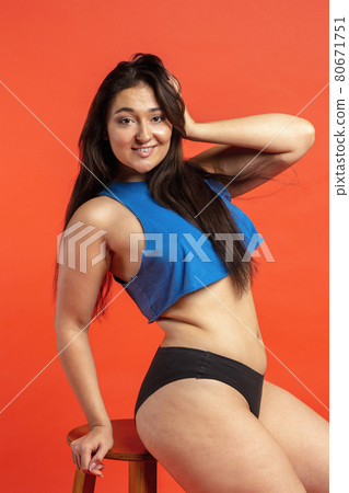 Young beautiful plump woman in cotton underwear on orange background Young beautiful plump woman in cotton underwear on orange background 80671751
