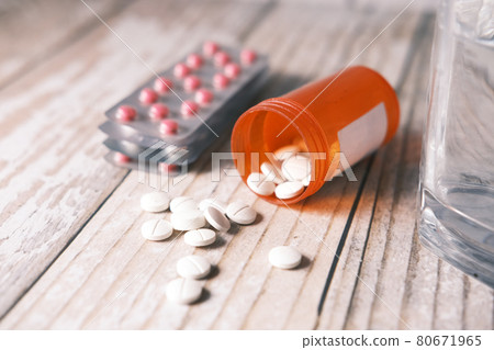 white color medical pills spilling on table  80671965