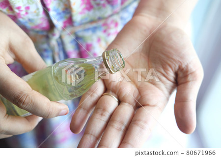 pouring hair oil on hand close up  80671966