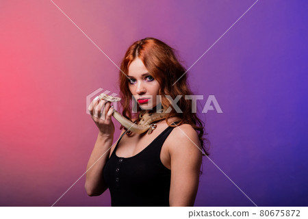 Young woman in black bikini posing with python against abstract studio background 80675872