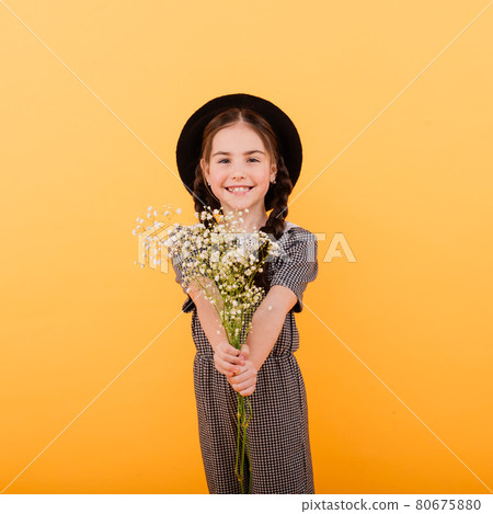 Portrait of cute little girl with flower bouquet in the studio. Congratulation, spring concept. 80675880