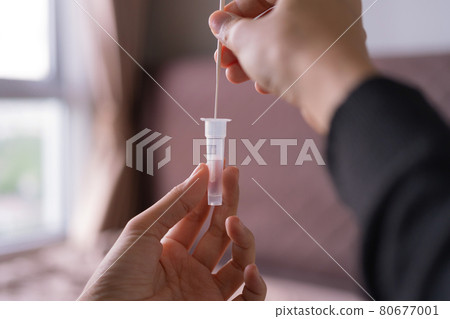 Hand holds a test cartridge at home. COVID-19 Ag rapid self test kits on bed at home in quarantine. Antigen or Antibody test. Virus disease healthcare check. Coronavirus outbreak. 80677001