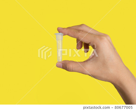 Hand holds a nasopharyngeal swab isolated on yellow background. COVID-19 Ag rapid self test kits. Antigen or Antibody test. Virus disease healthcare check. Coronavirus outbreak. 80677005