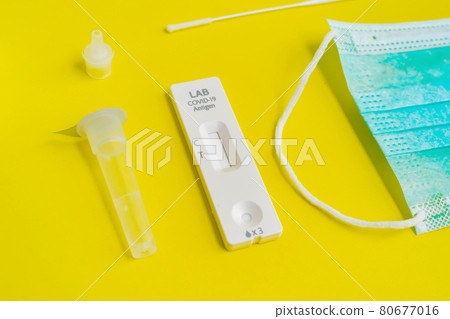A set of COVID-19 rapid self test kits with medical equipment isolated on yellow background. Antigen or Antibody test. Face mask, Thermometer and pulse oximeter. Virus disease healthcare check. 80677016