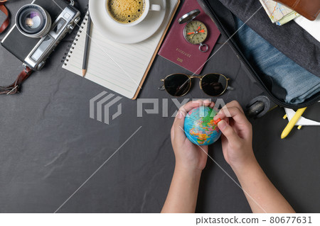 Pin on the world map and Prepare a suitcase  on black background. travel concept 80677631